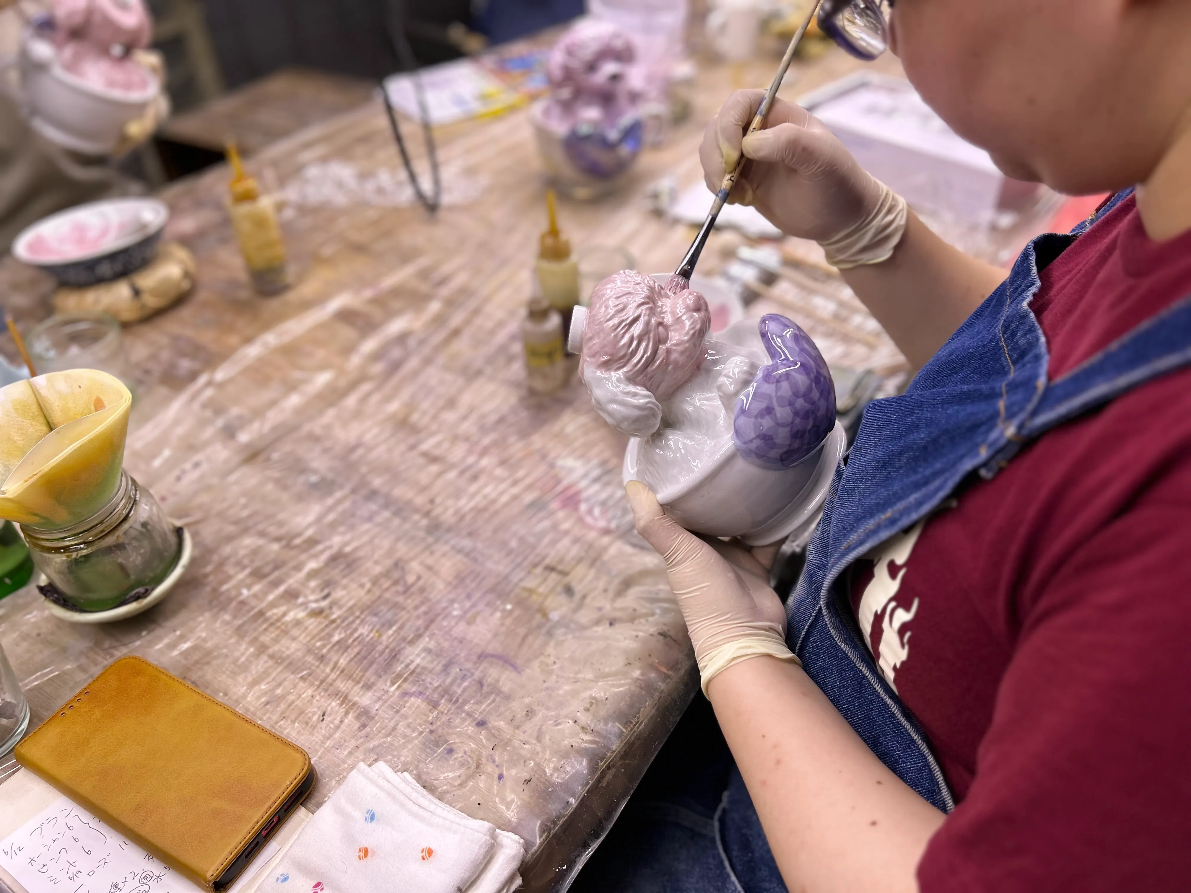 本焼成された商品を熟練された職人により、筆やスプレー等で素地の表面に絵を施していきます。